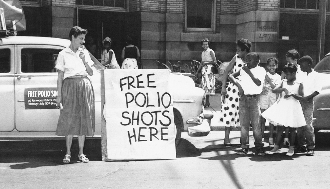 item 3 of Gallery image - woman is announcing free polio shots at a public school in nineteen fifty six