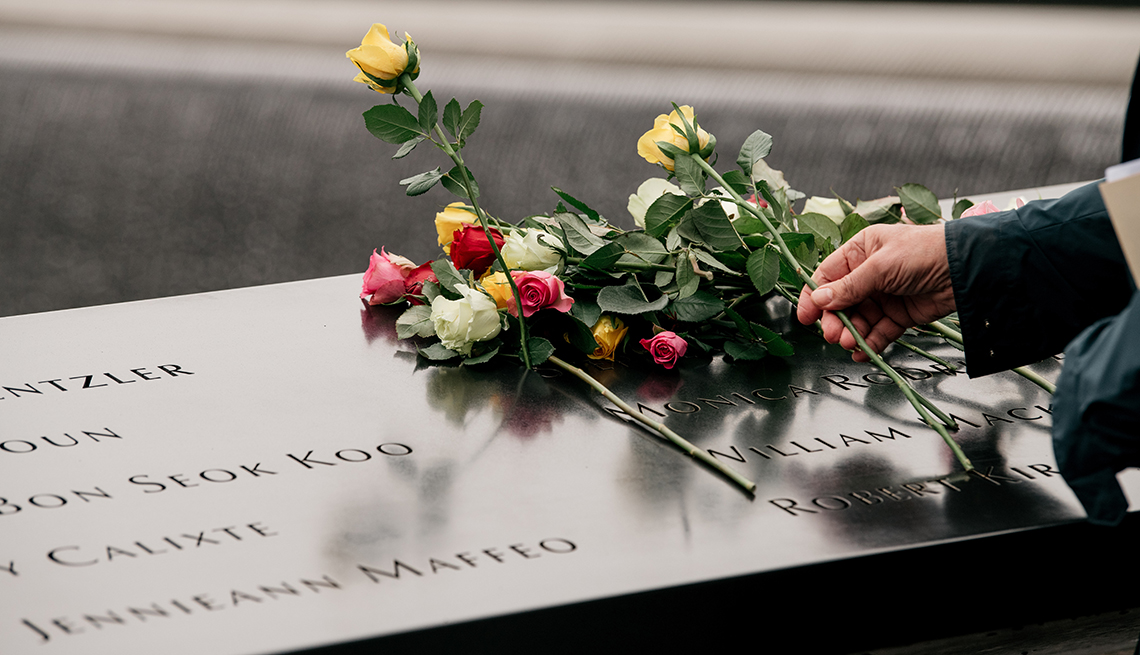 Los familiares de las víctimas del ataque al World Trade Center colocan rosas sobre una placa 