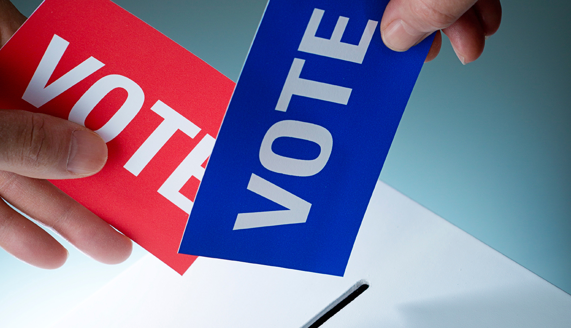 Votos de color azul y rojo listos para ser depositados en una urna