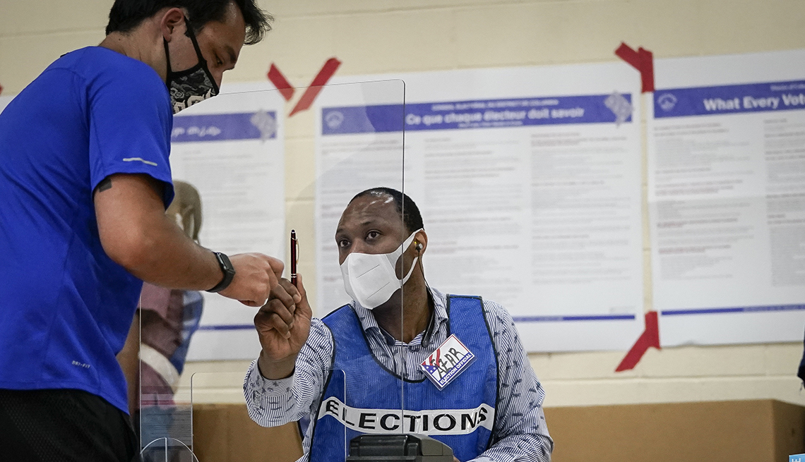 A person is talking to another person at a polling location during the election