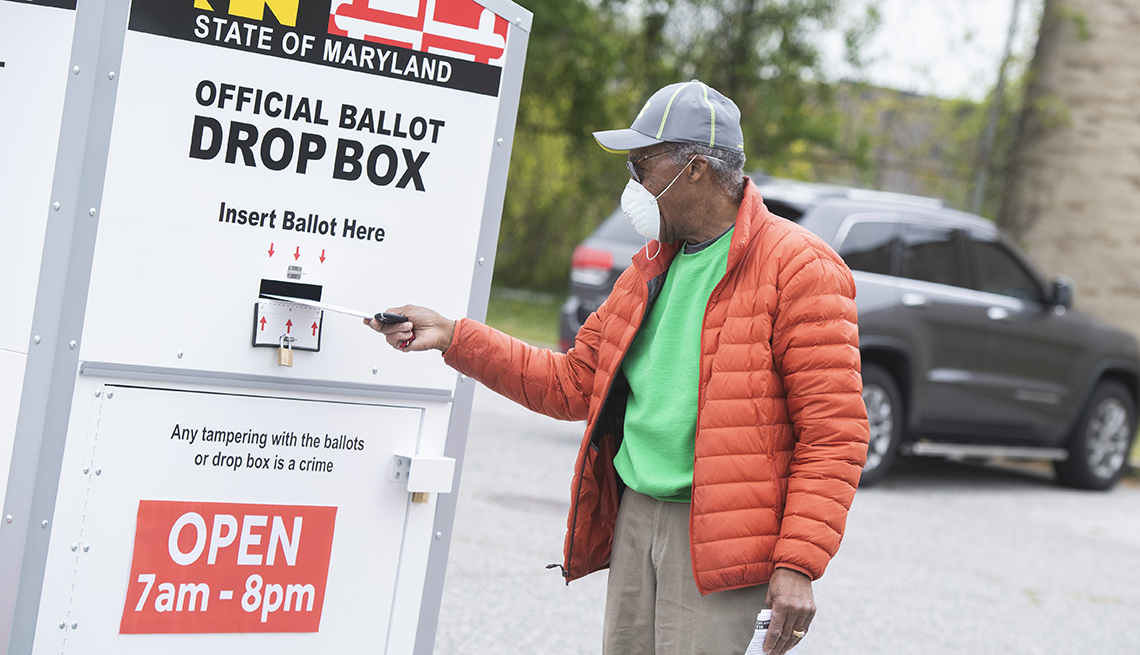 Una persona deposita su voto en un buzón
