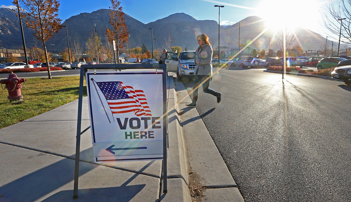 A woman walks into a voting location with a sign that says vote here