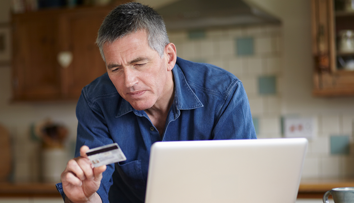 Man, looking at credit card, computer, inside a house, Public Policy Institute, Consumer Protection
