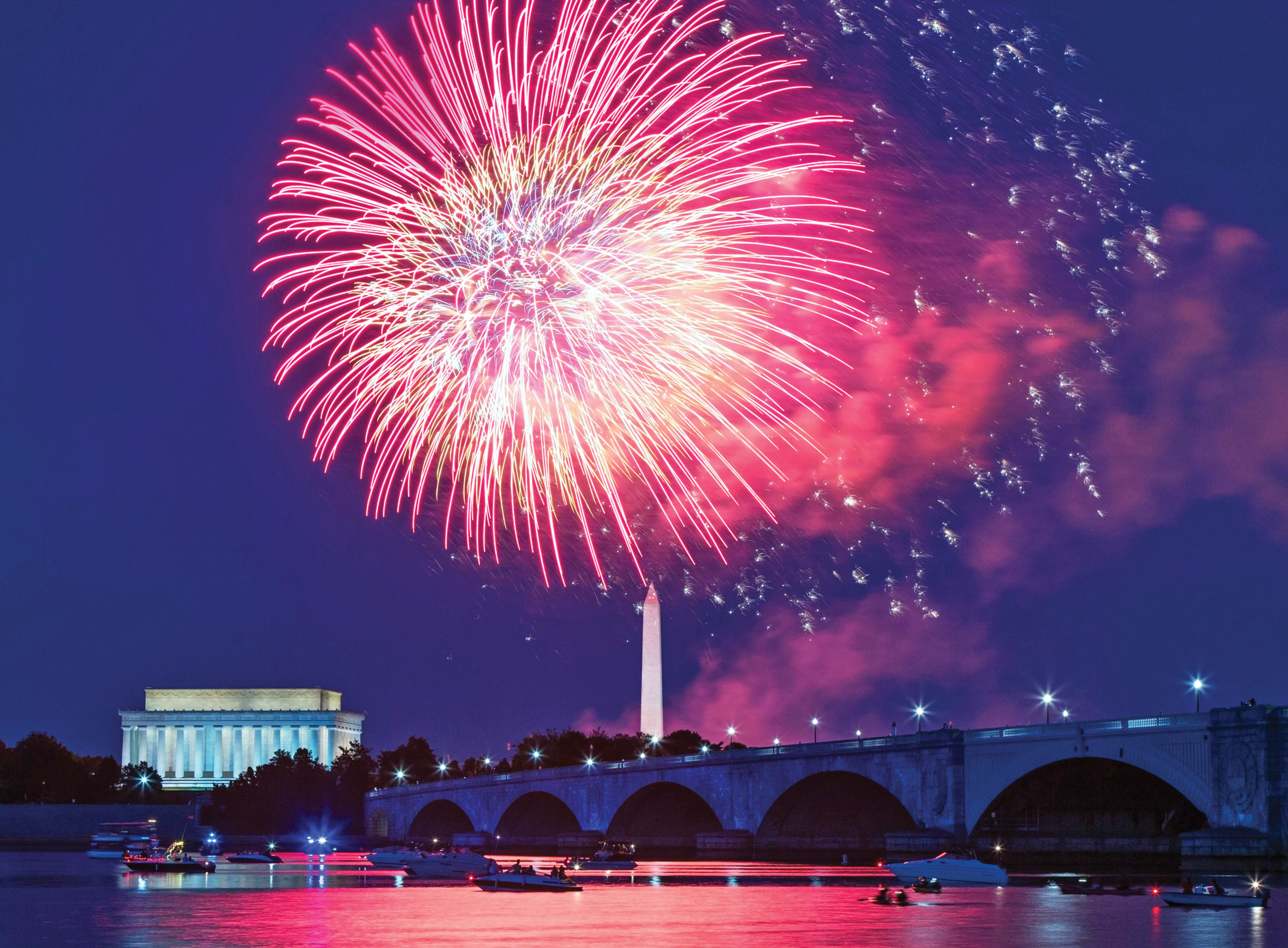 Photograph of the skyline of DC lit up with fireworks with Washington monument at the center of it.