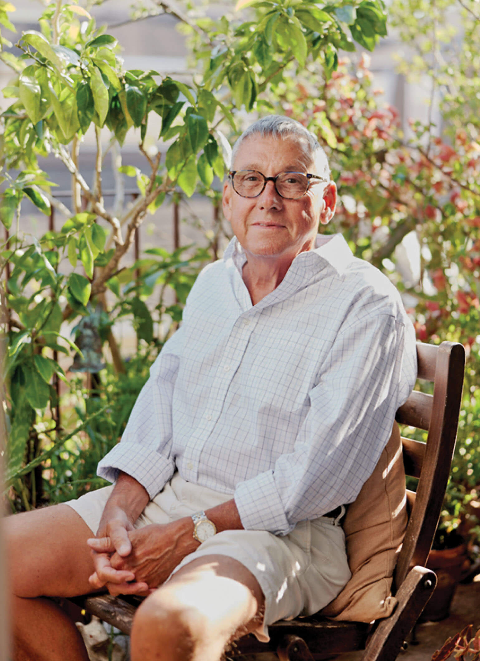 A bespecticled caucasian man, Robbie Dickson, sitting outdoors.