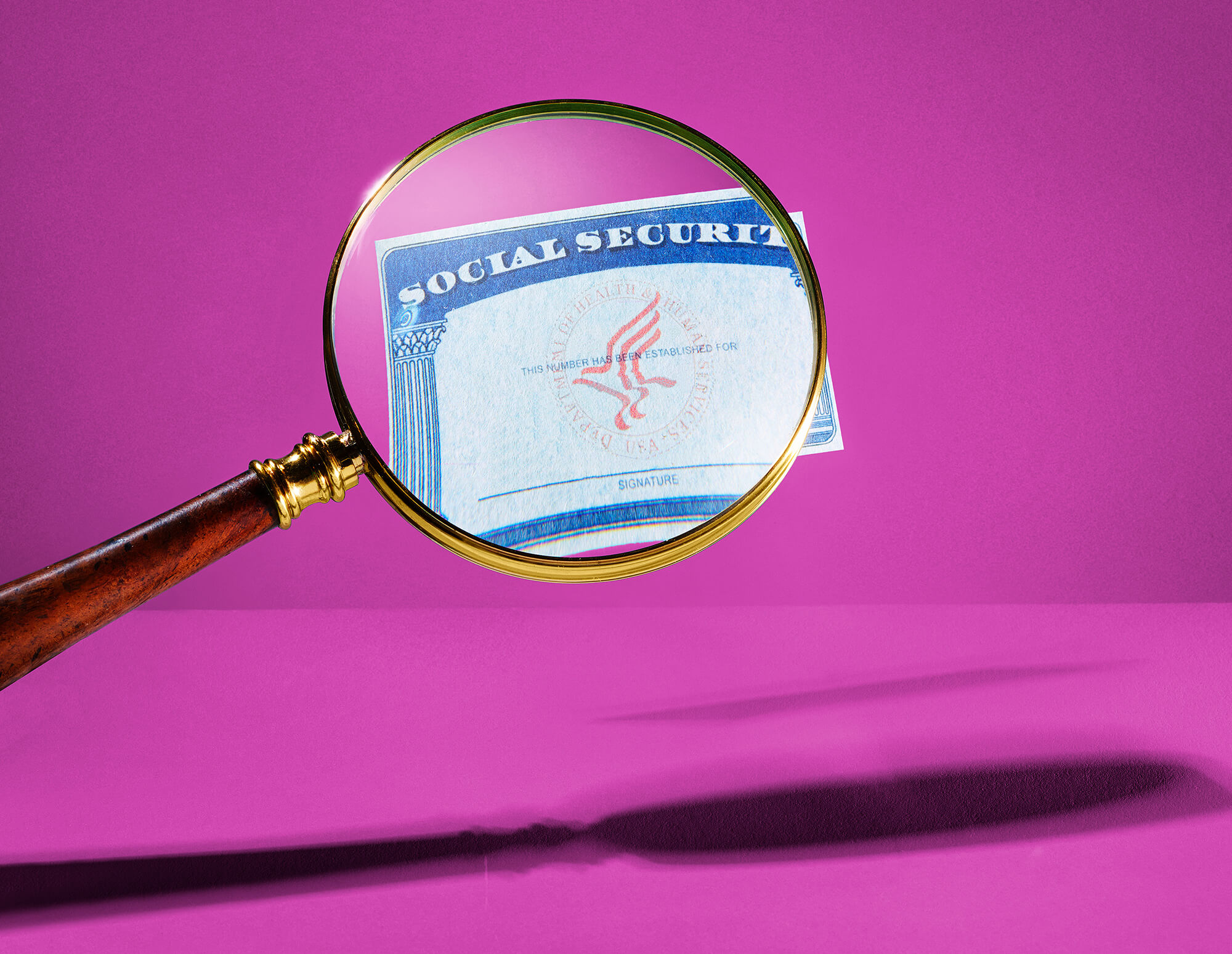 Photo of a magnifying glass overing over a social security card