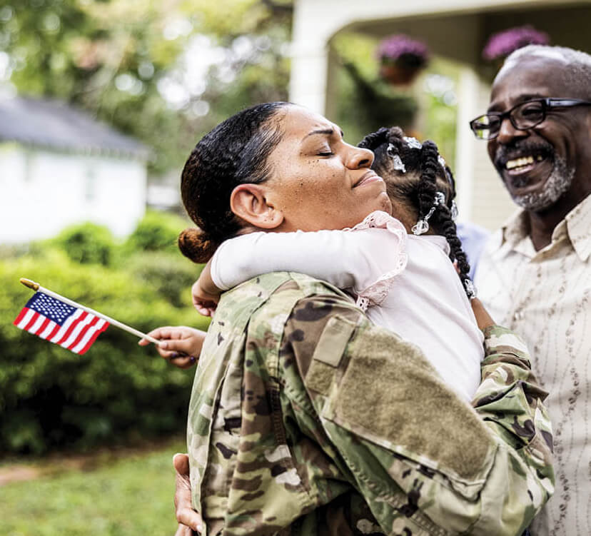 Photo of a woman in an Army uniform hugging a young girl