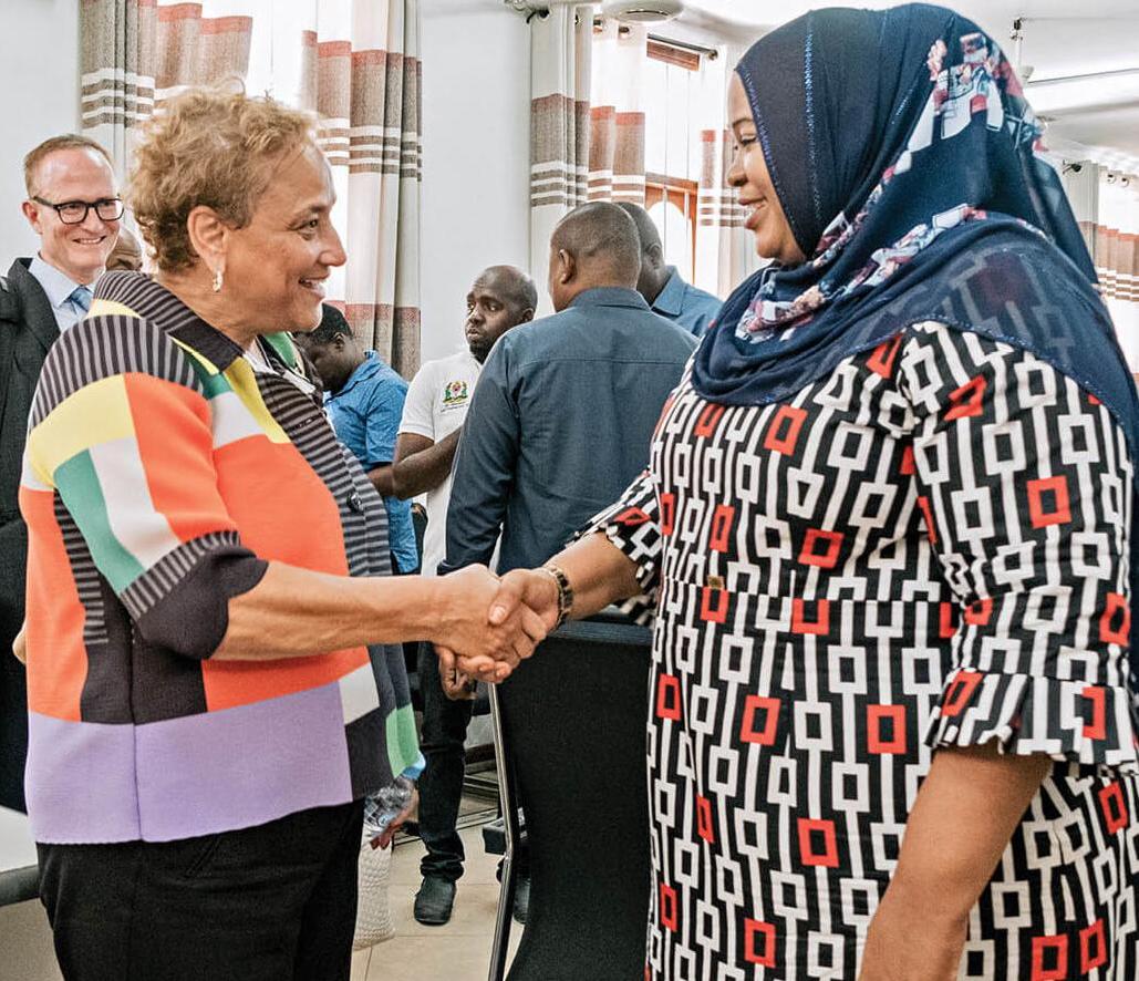 Photo of AARP CEO Jo Ann Jenkins shaking a woman's hand on an international trip