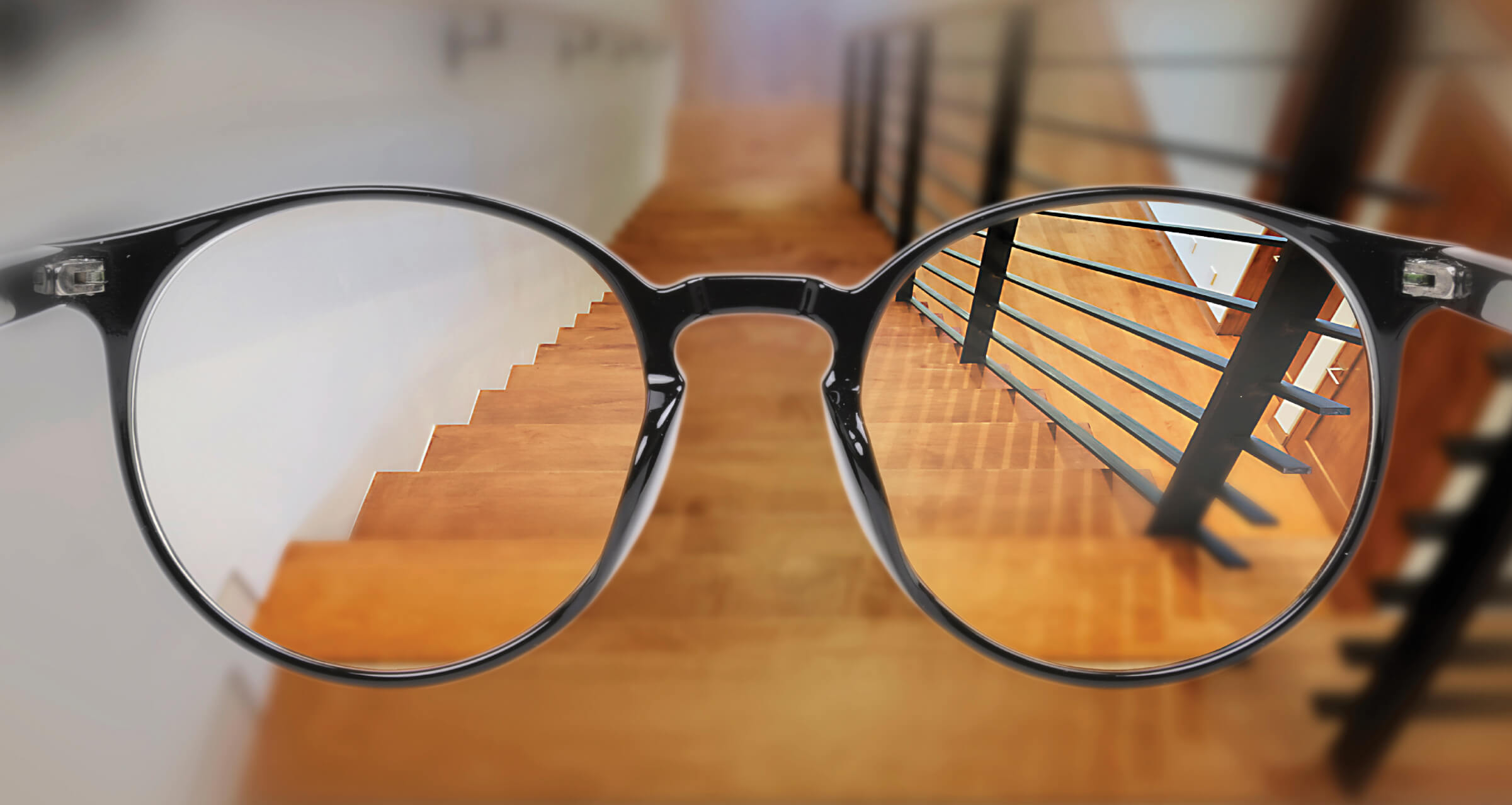 Photo illustration of a pair of glasses over a staircase, parts of the lenses are blurry