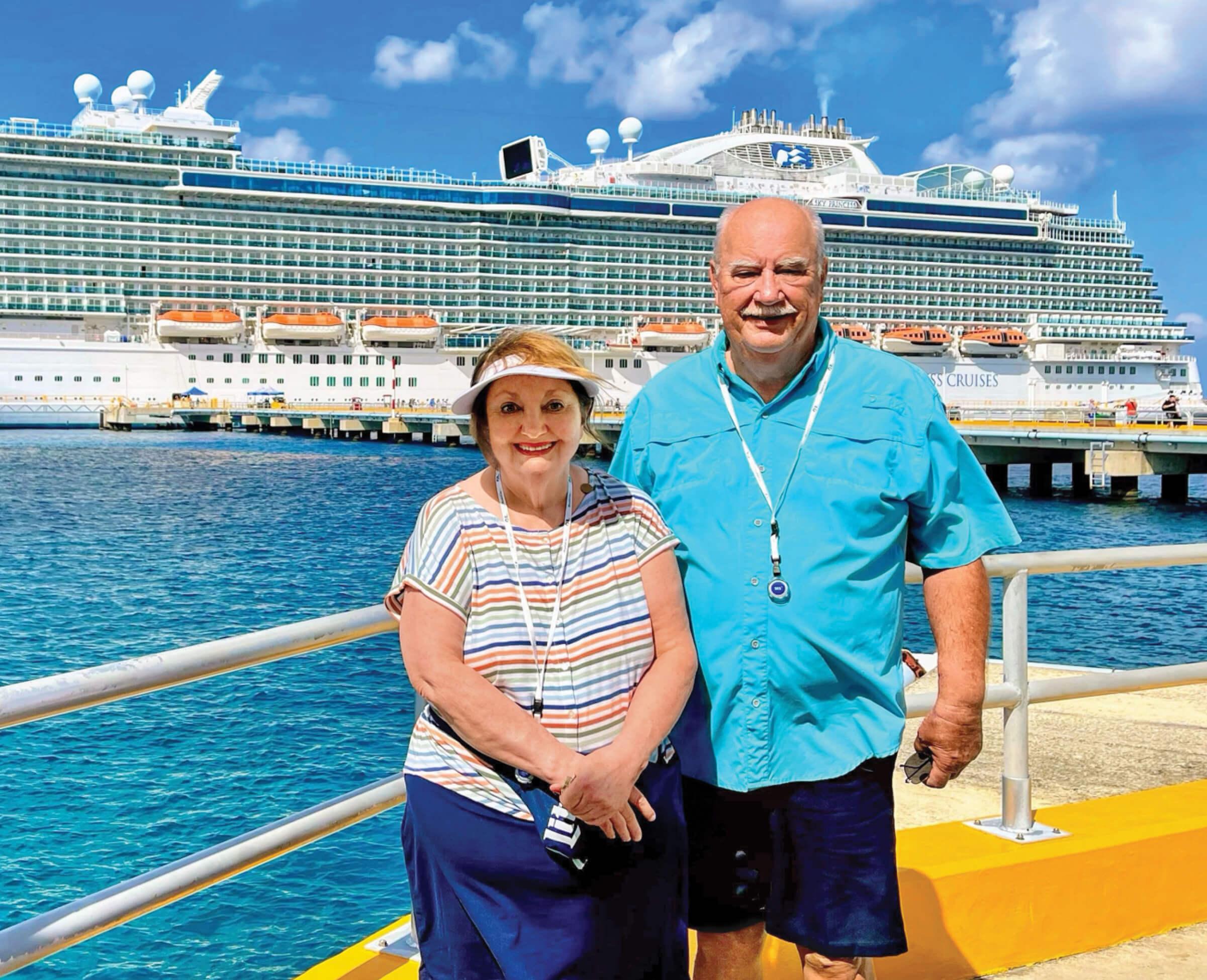 Judy Bailey and her husband Forrest standing in front of a ship.