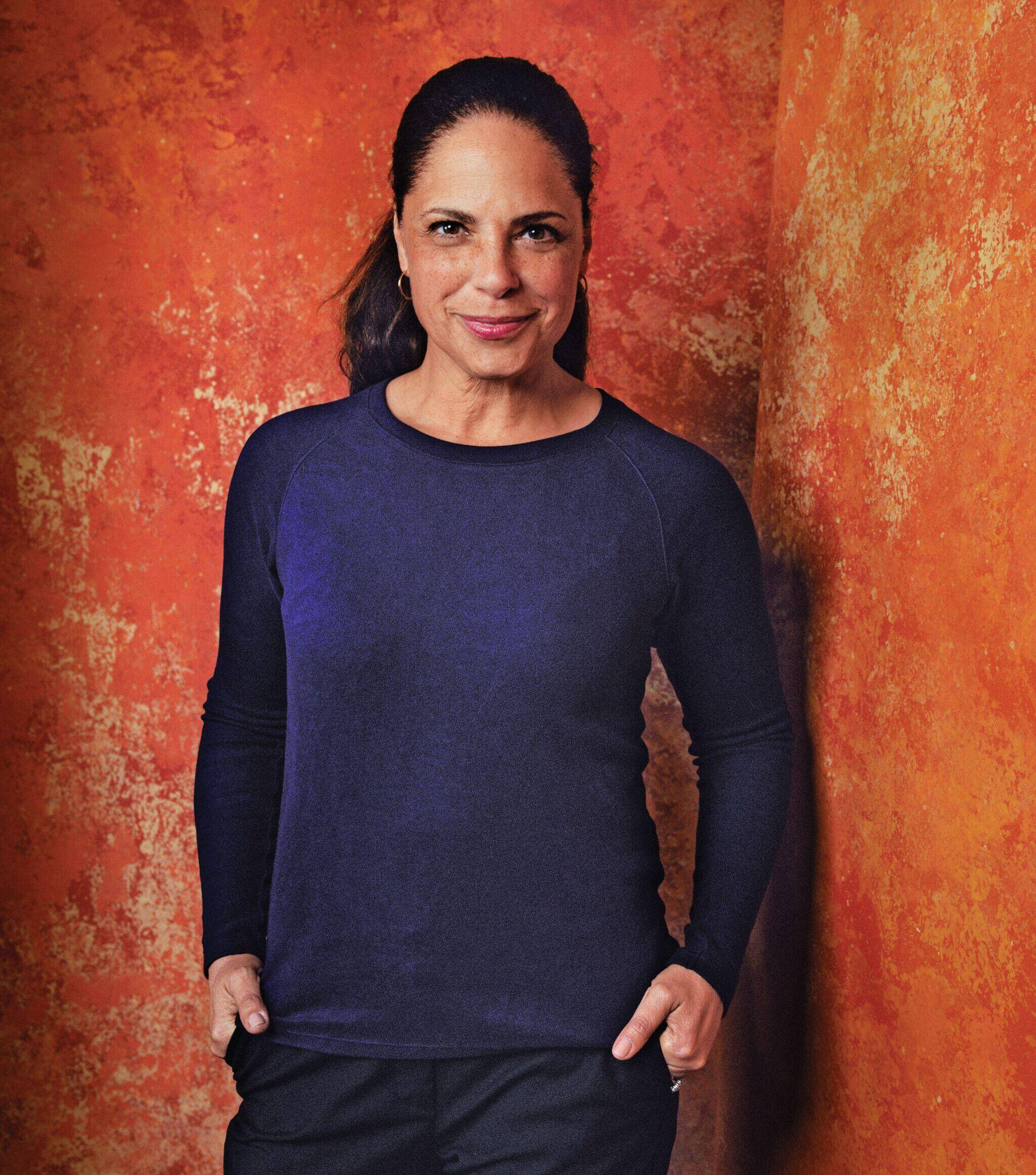 Photograph of Soledad O’Brien standing against a wall and wearing a dark blue sweater