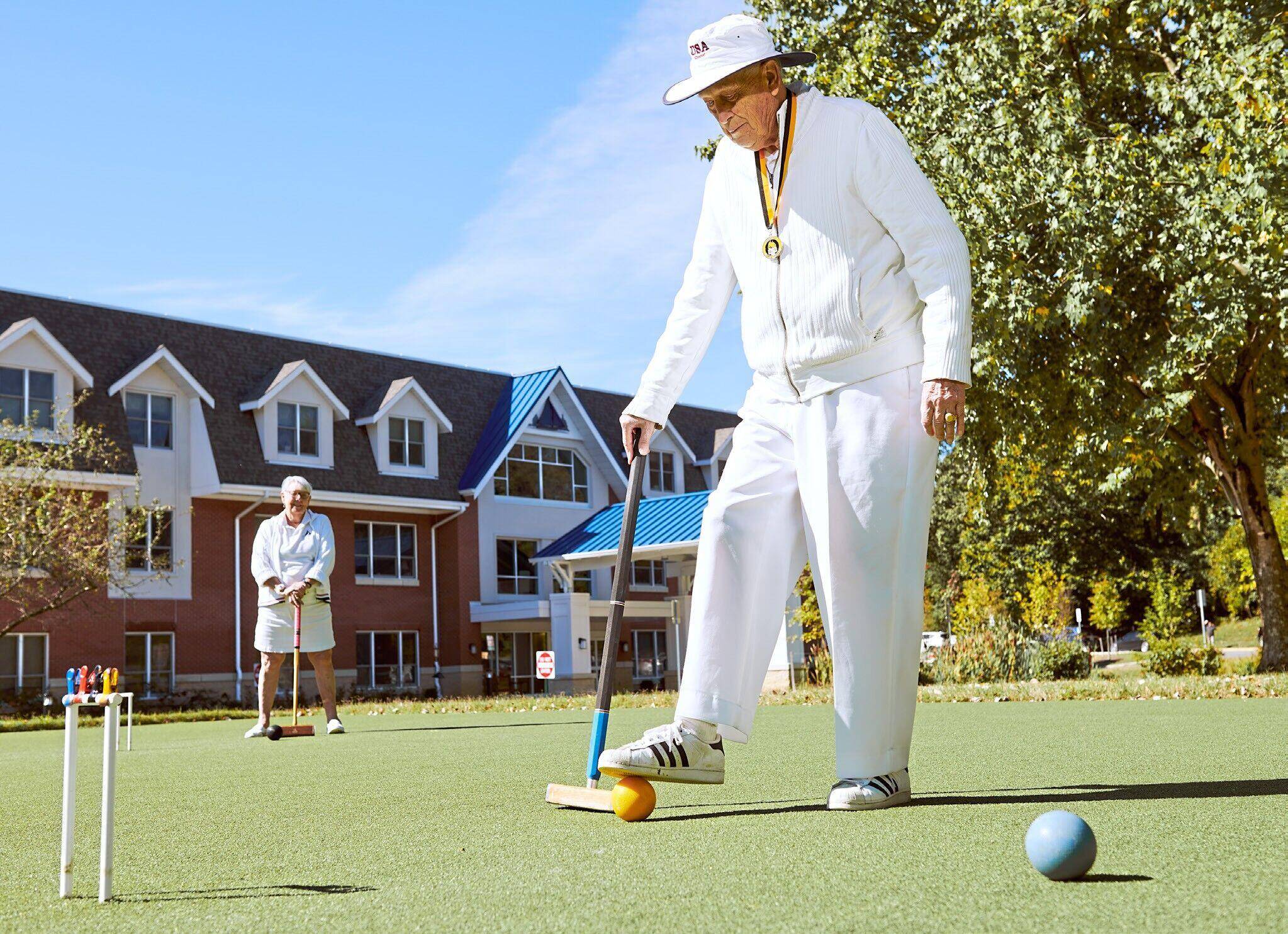 Photo of Byron Lee playing croquet on a sunny day.