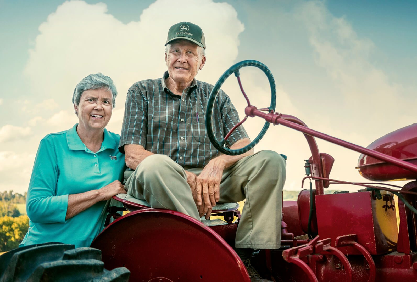 Photo of Nancy and David Greene with an antique tractor