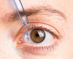 Photo showing prescription eye drops on an eye