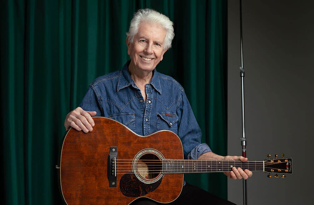 Photo of Graham Nash holding a guitar