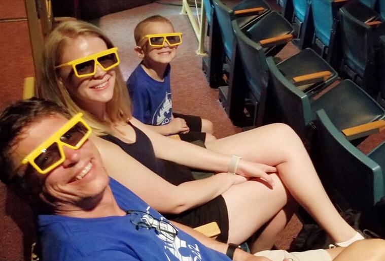 Photo of 3 Breeling family members wearing yellow 3D glasses in a theater at Disney World