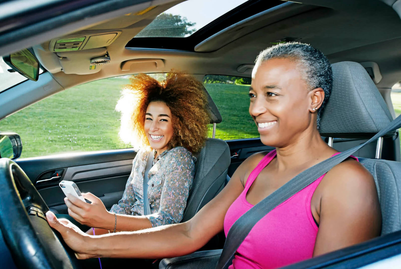 Photo of two happy women driving in a car
