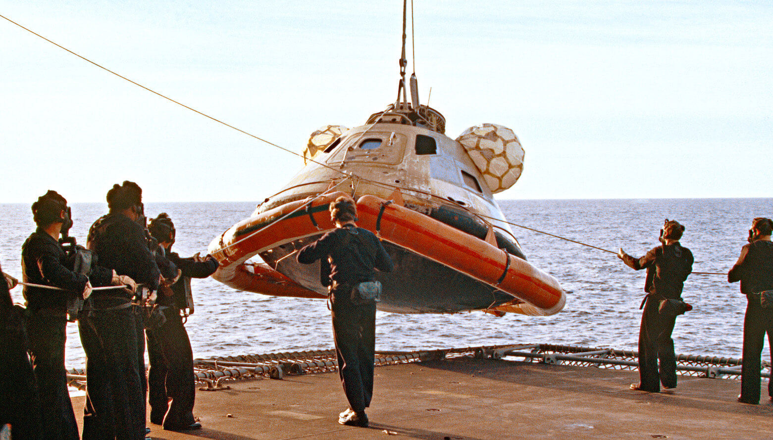 Photo of the SkyLab module being hoisted onto the deck of a ship upon its return from the U.S. space station