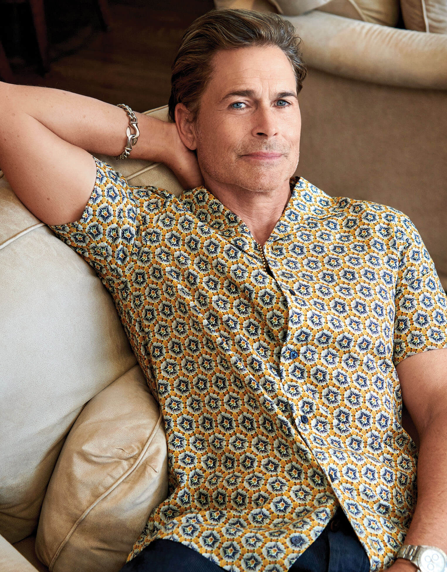 Photo of Lowe lounging in a yellow patterned shirt