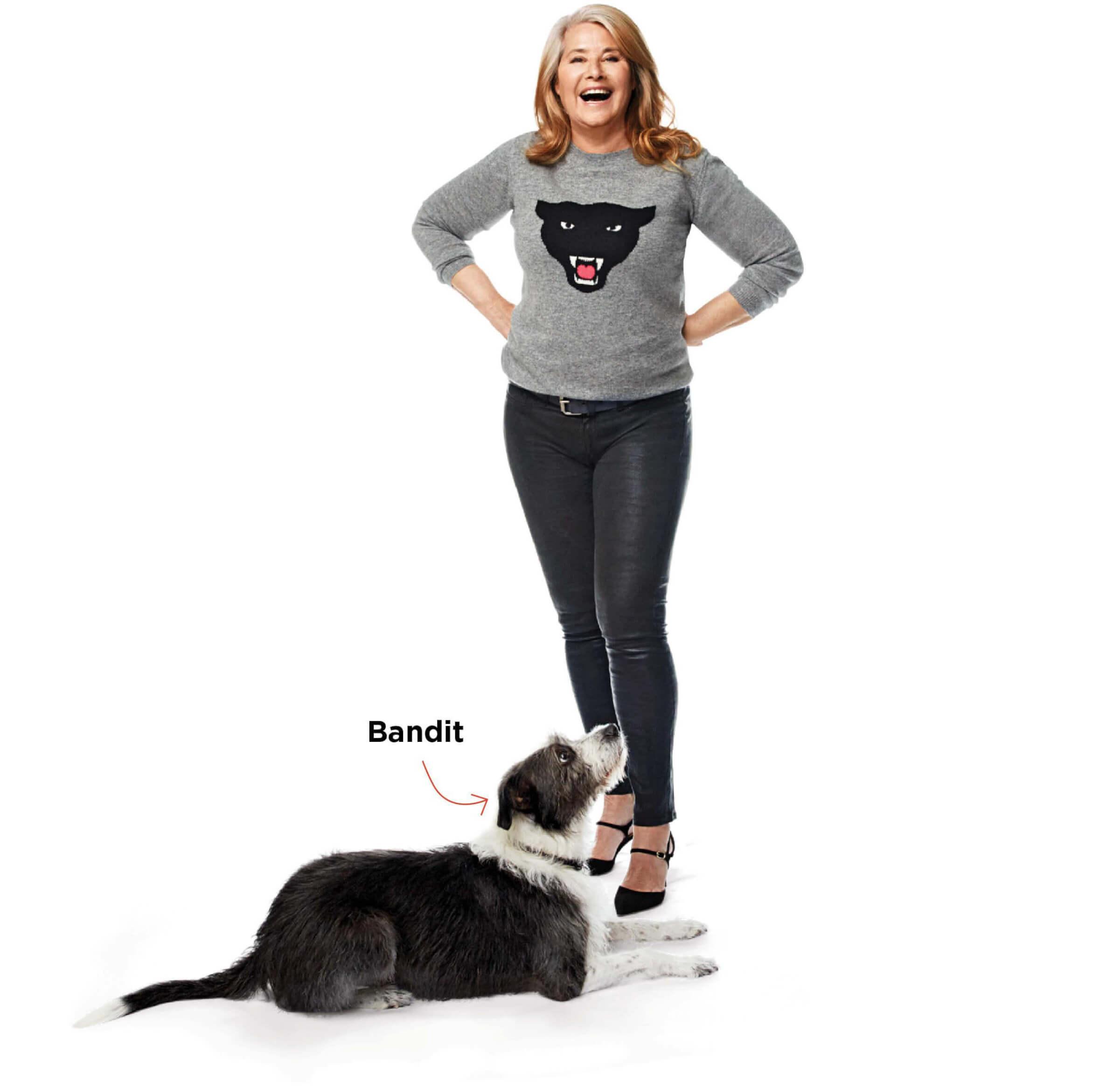 Photo portrait of Lorraine Bracco standing with her dog Bandit at her feet