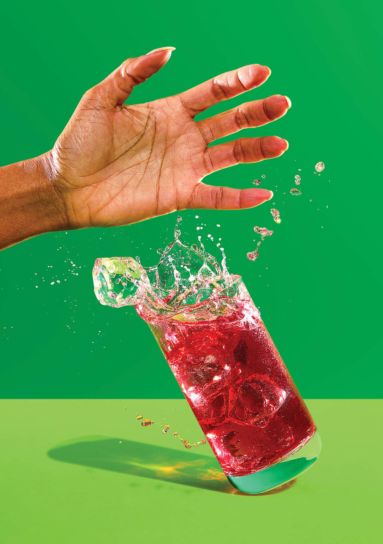Photo illustration of a hand dropping a drink glass