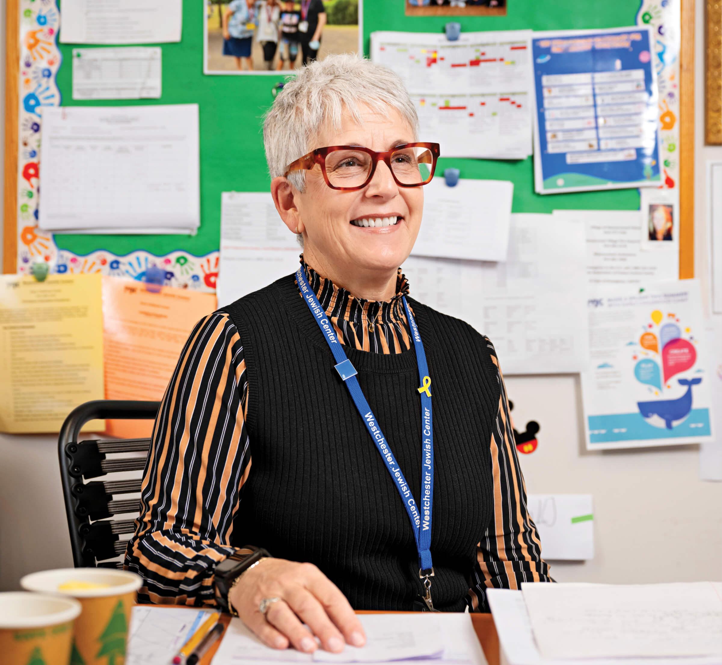 Photo of Ann Pircio Pardes sitting at her desk in her classroom