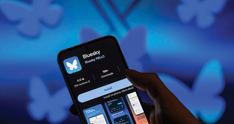 Photo of person downloading Bluesky on their iPhone