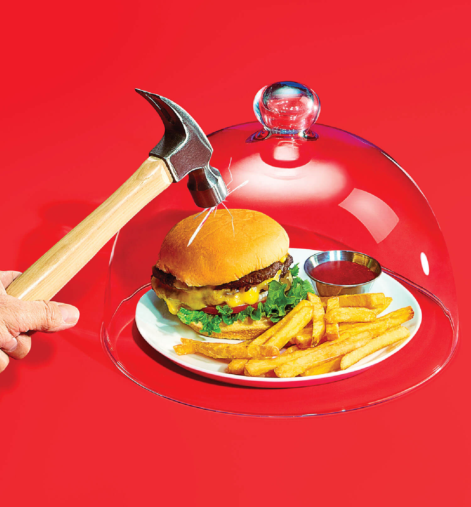 Photo illustration of a cheeseburger and fries under a glass cover, a hand with a hammer is trying to crack the glass