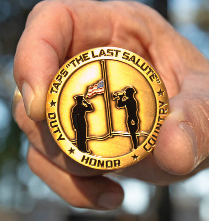 Photo of Bragan holding a TAPS medallion