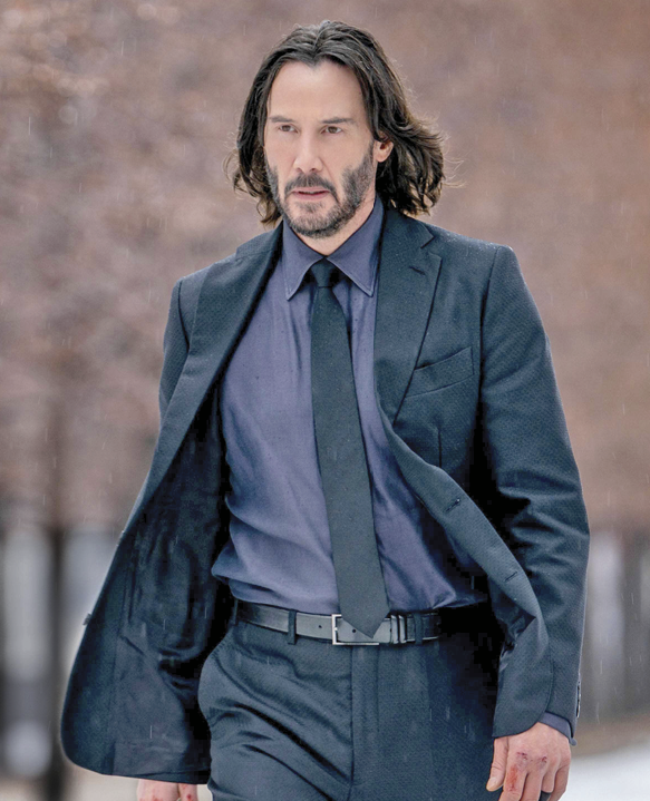 Photograph of Keanu Reeves wearing a blue suit and walking