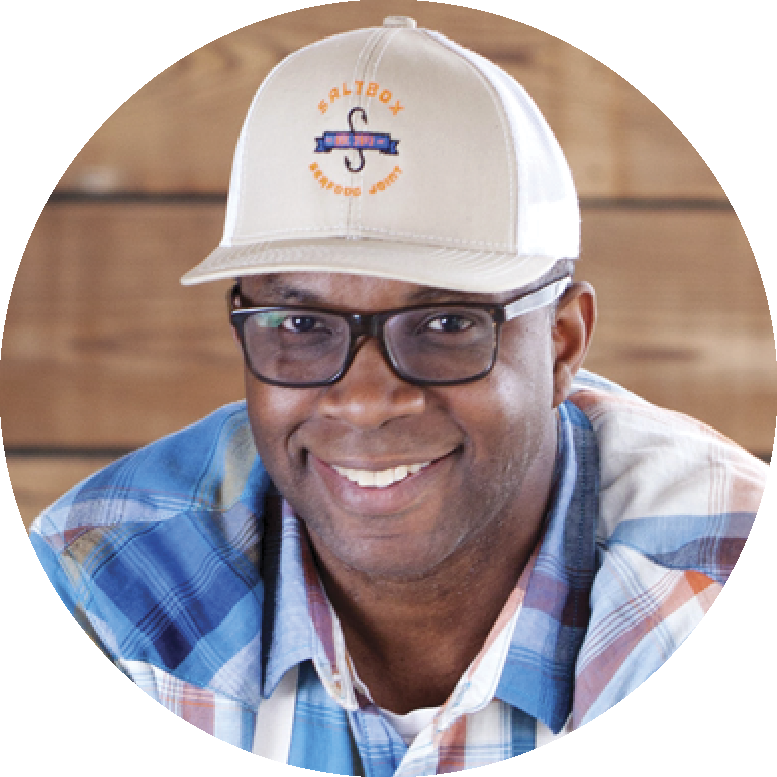 Ricky Moore wearing a blue plaid shirt and a baseball cap