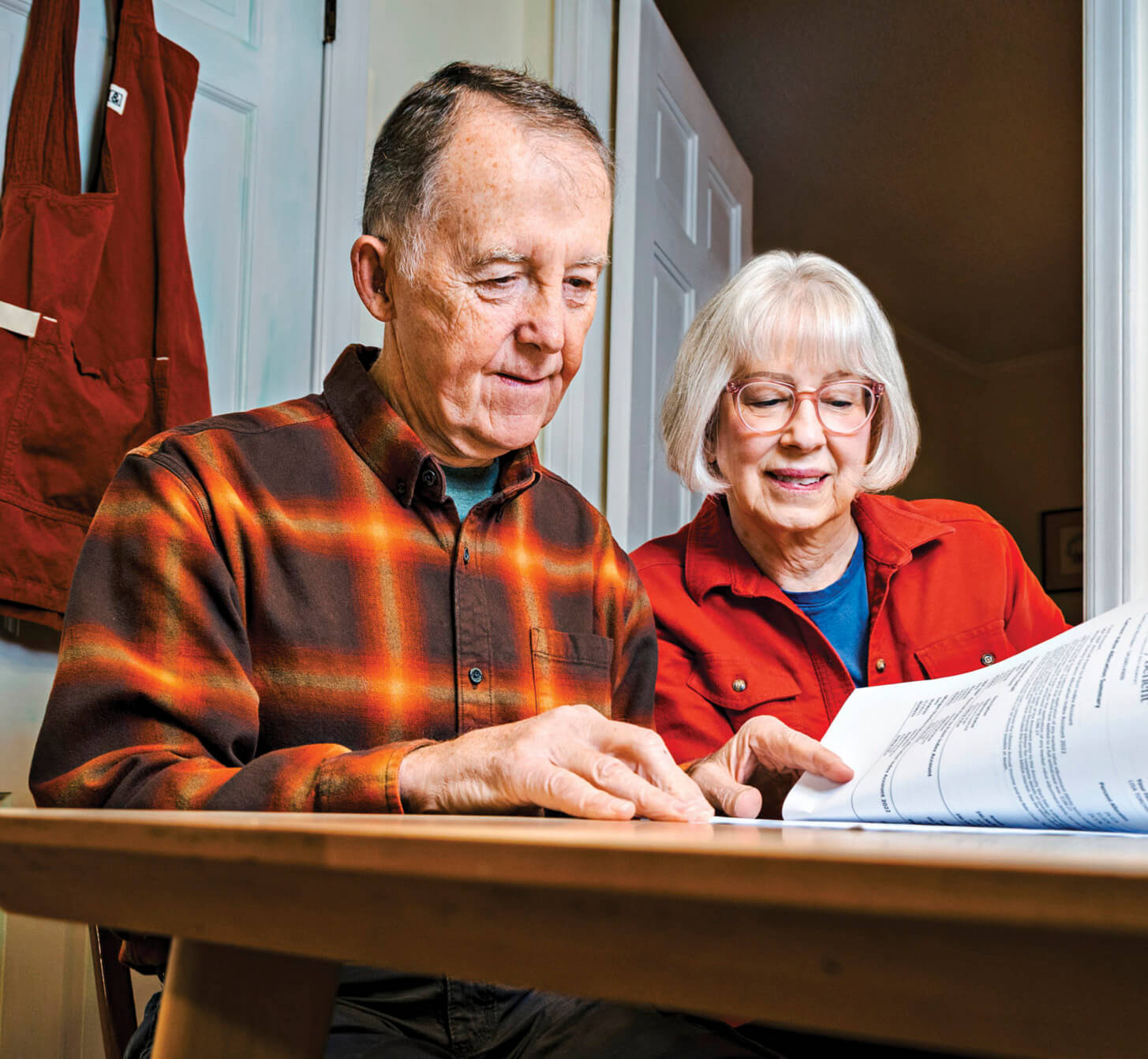 Photograph of Joe and Ellen Donahue sitting at a table and going over charts