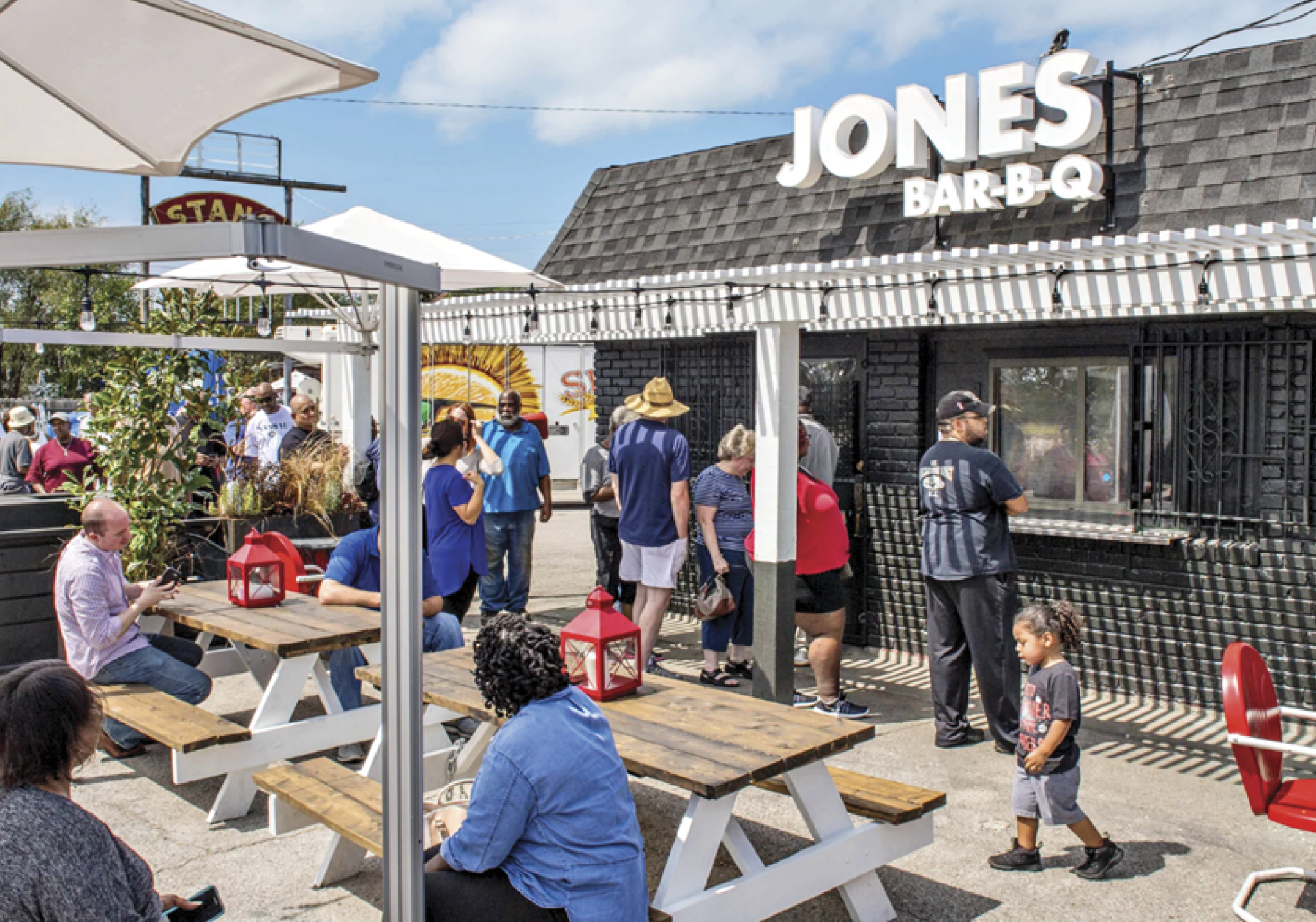 Photograph of their restaurant from outside with a line of people outside 