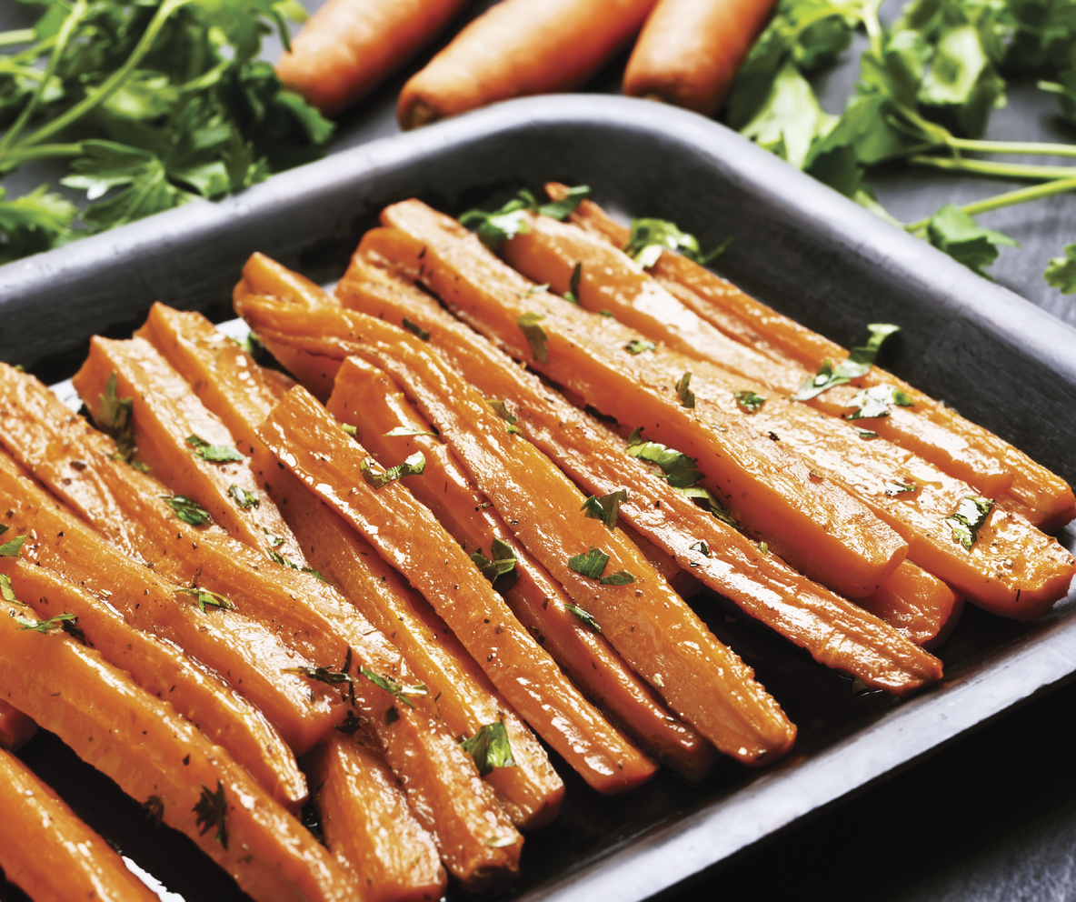 Photograph of a baking tray with thinly sliced carrots