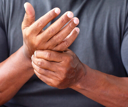 Photo of a man holding his hands in pain