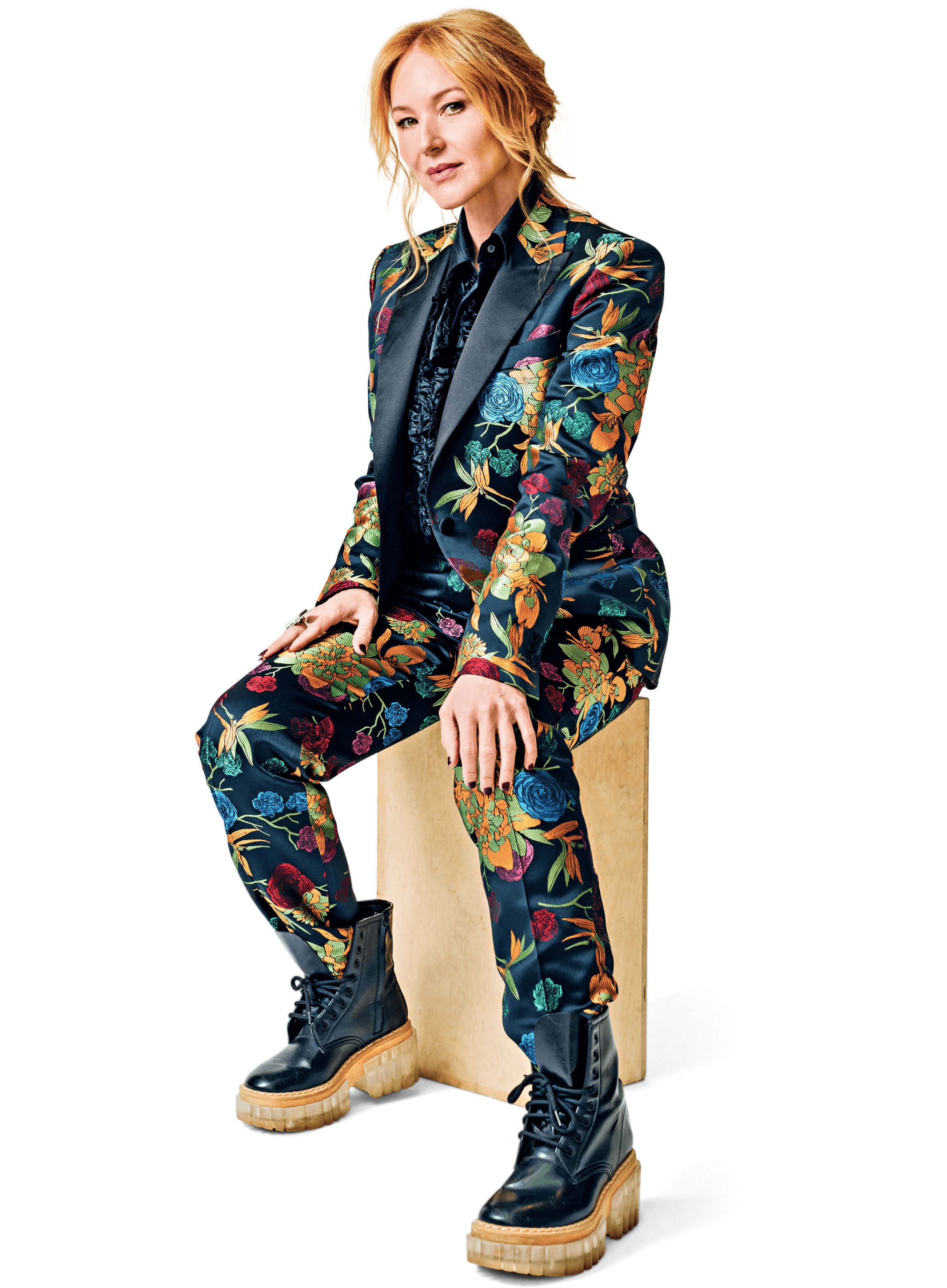 Portrait of Jewel, seated, wearing a colorful floral patterned suit