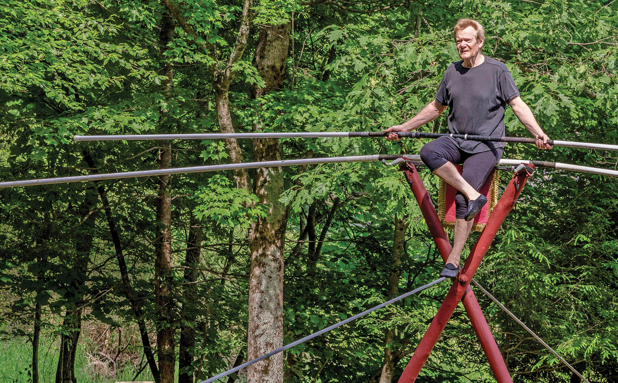 Photo portrait of Philippe Petit on a tightrope at his home