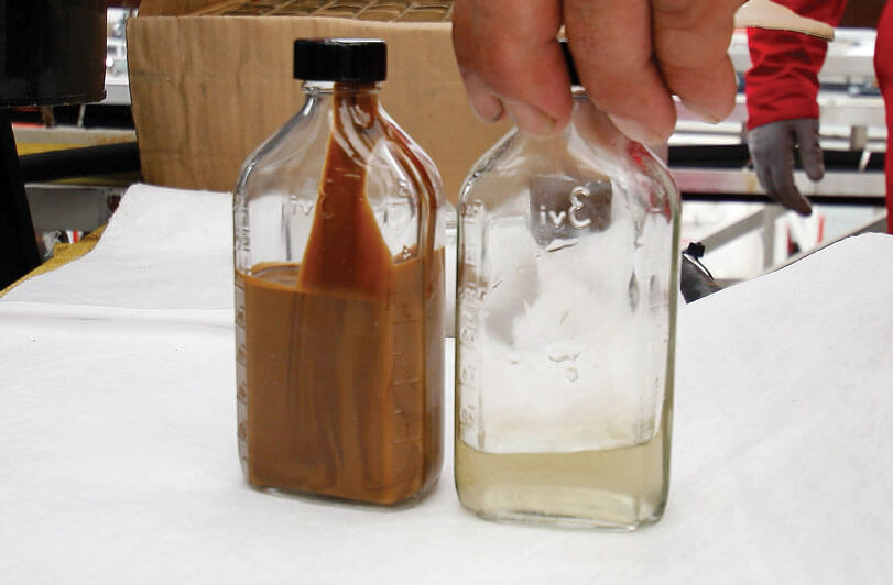 Photo of before-and-after samples show oil-contaminated water treated with Costner’s centrifuge device.