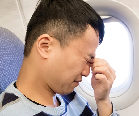 Photo of man holding his head in pain