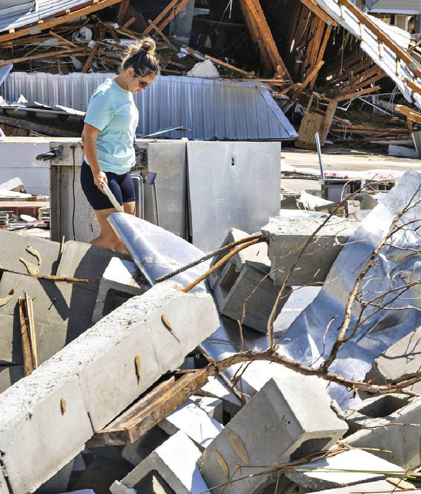 Photo of woman walking in debris after Hurricane Helene