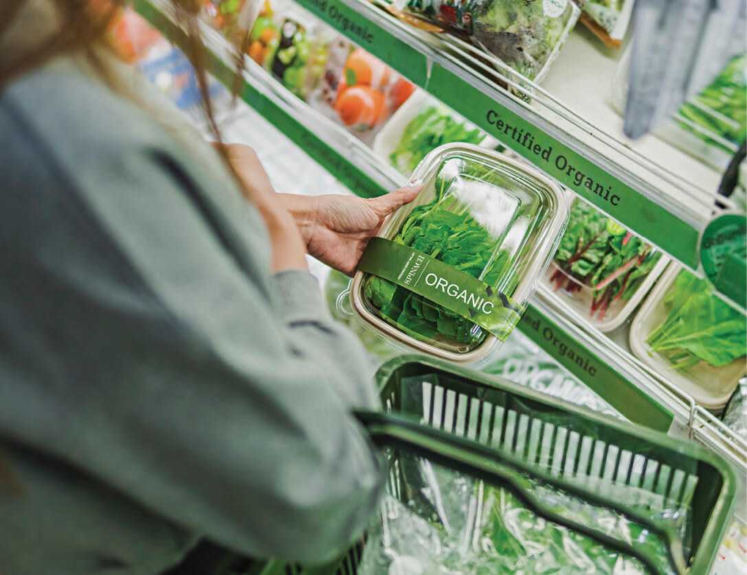 Image of a person buying organic greens at a grocery store 