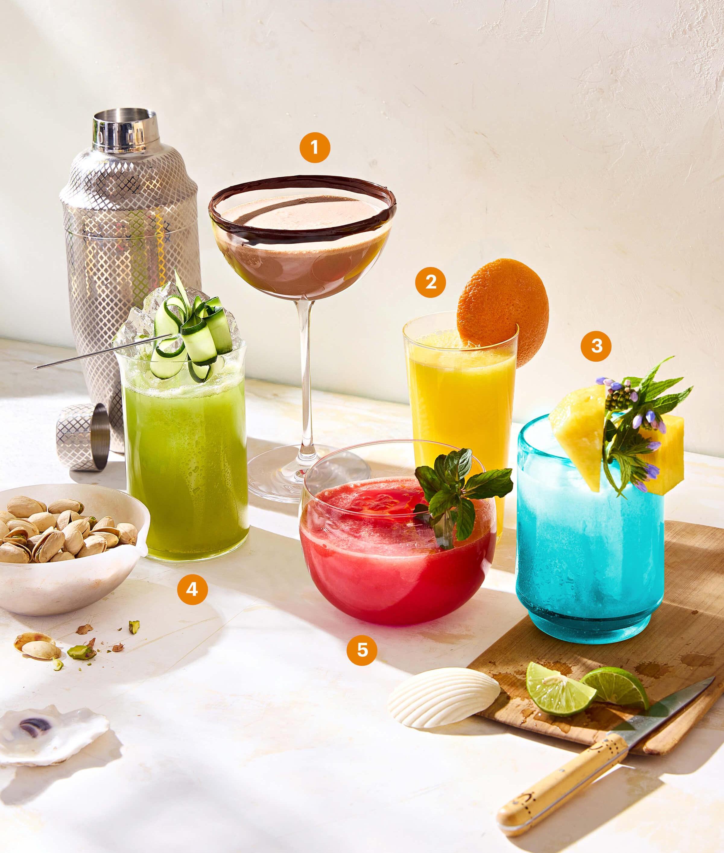 Table spread with several different colorful mocktails in different types of glasses 