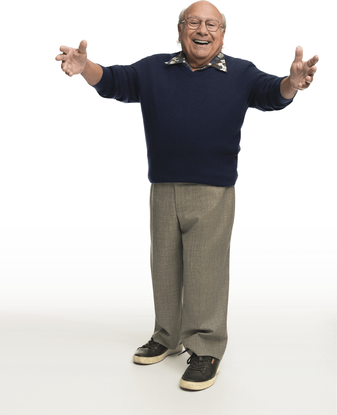 Danny DeVito standing up and looking at the camera with a big smile on his face. 