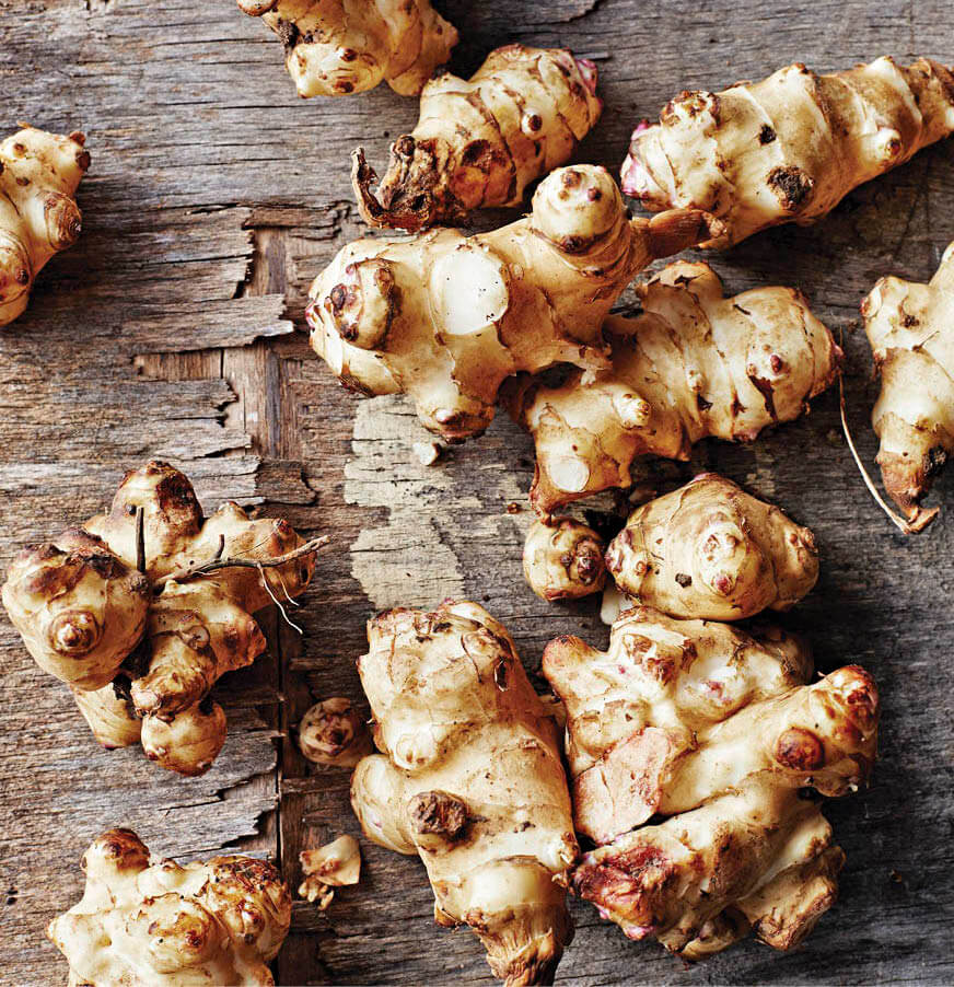 Photo of several sunchokes on a wooden table