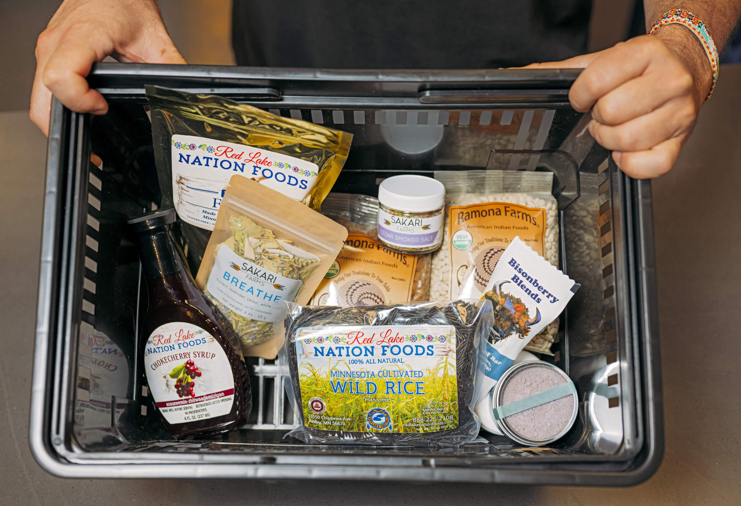 Photo of Sean Sherman's shopping basket full of items such as cedar smoked salt, wild rice and chokecherry syrup