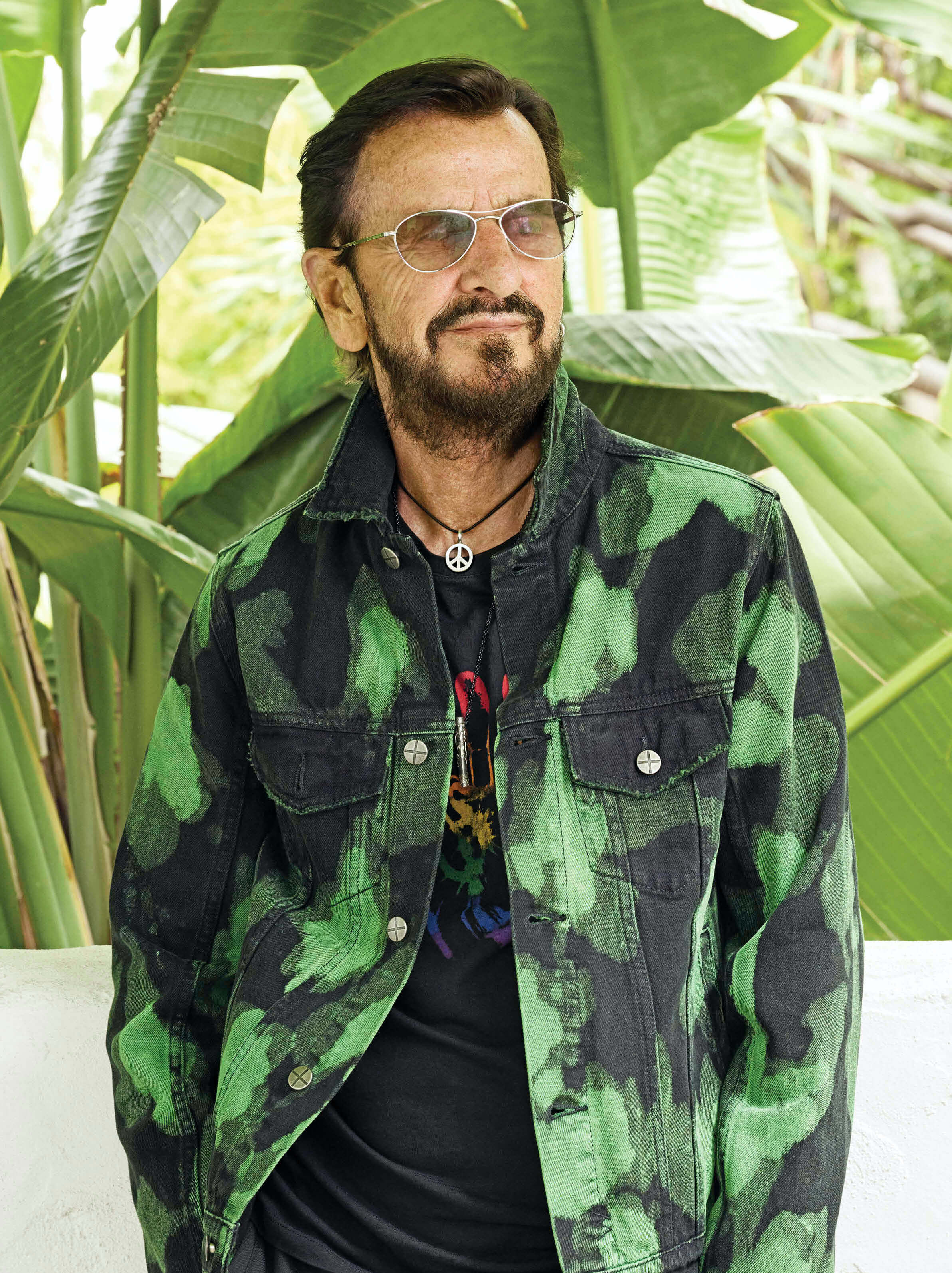 Photo of Ringo Starr wearing a green and black jacket and a black t-shirt