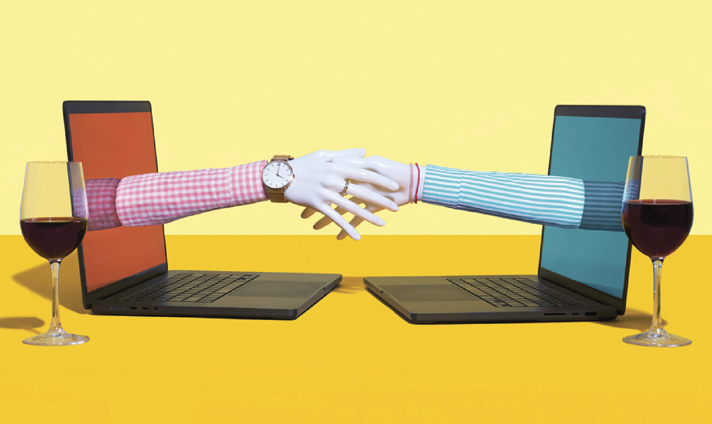 Photocollage of two laptop screens facing each other with wine glasses next to them. The laptop screens have hands reaching out from them that are shaking.
