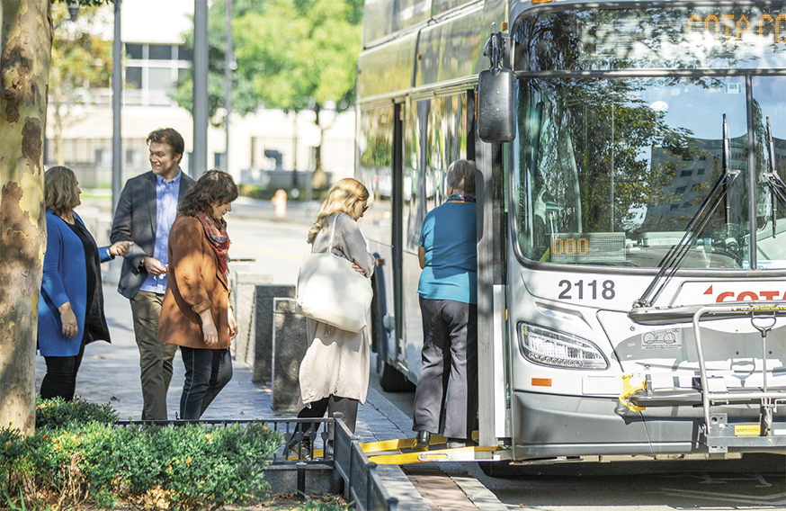 Image of a bus with several people getting on the bus 