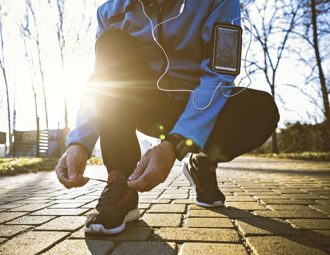 Photograph of a person tying their running shoes, ready for a run