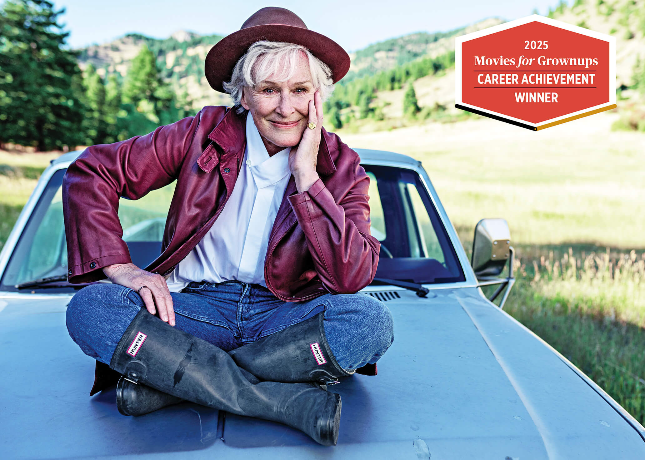 Photo of Glenn Close sitting on the hood of a car in Montana
